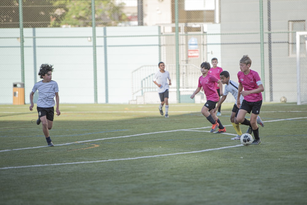 grupo de pessoas jogando futebol durante o dia