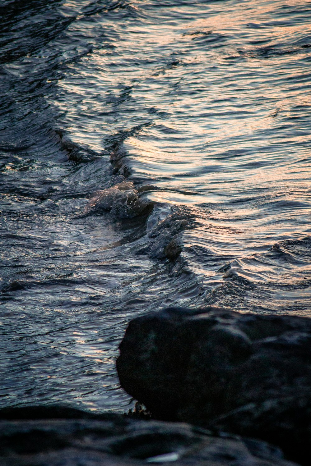 黒い岩に当たる水の波
