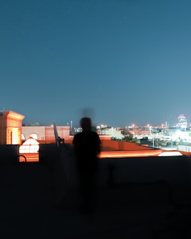 A shadowed figure observing a cityscape at night, symbolizing discreet surveillance