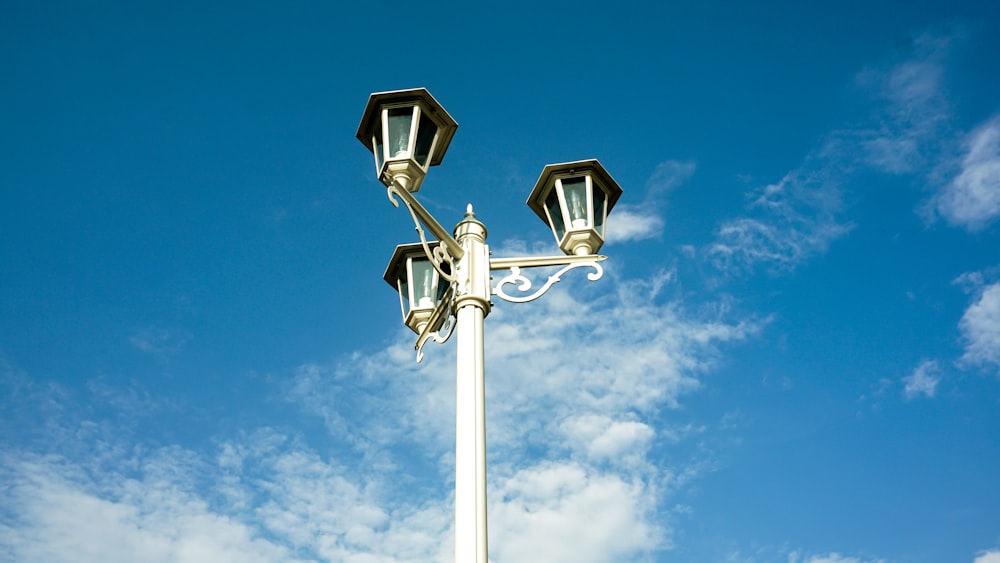 Farola blanca bajo cielo azul durante el día