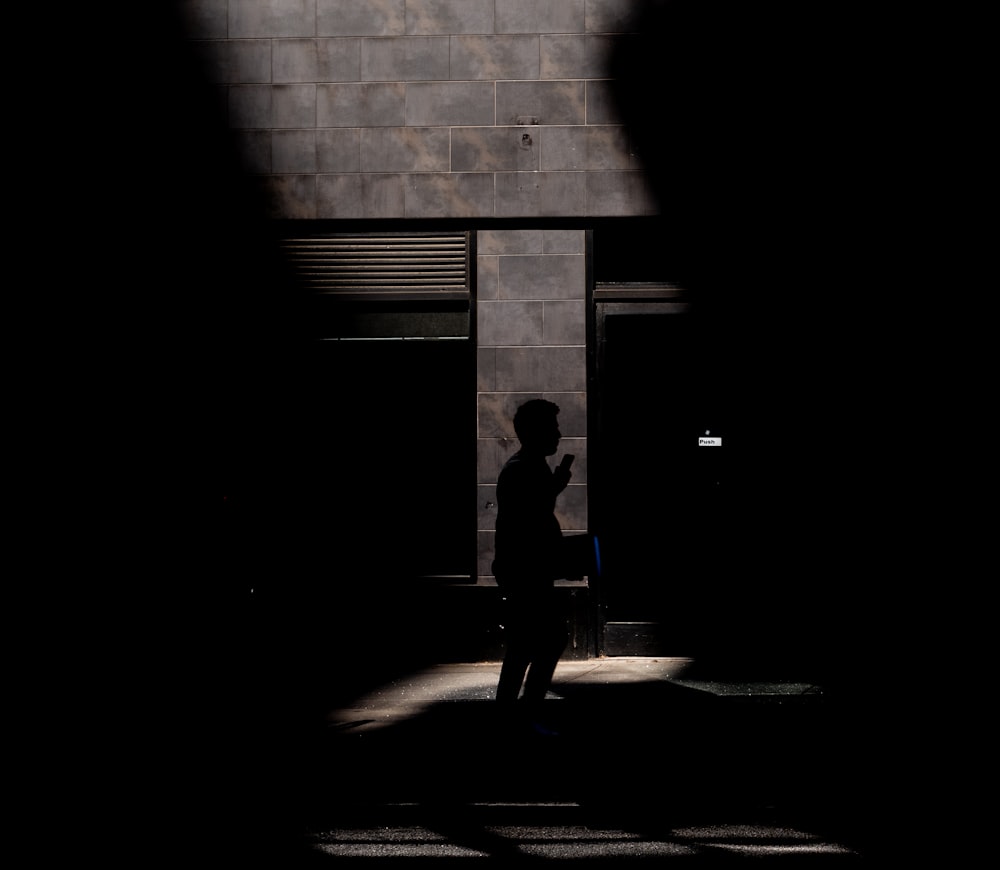 man in black jacket walking on hallway