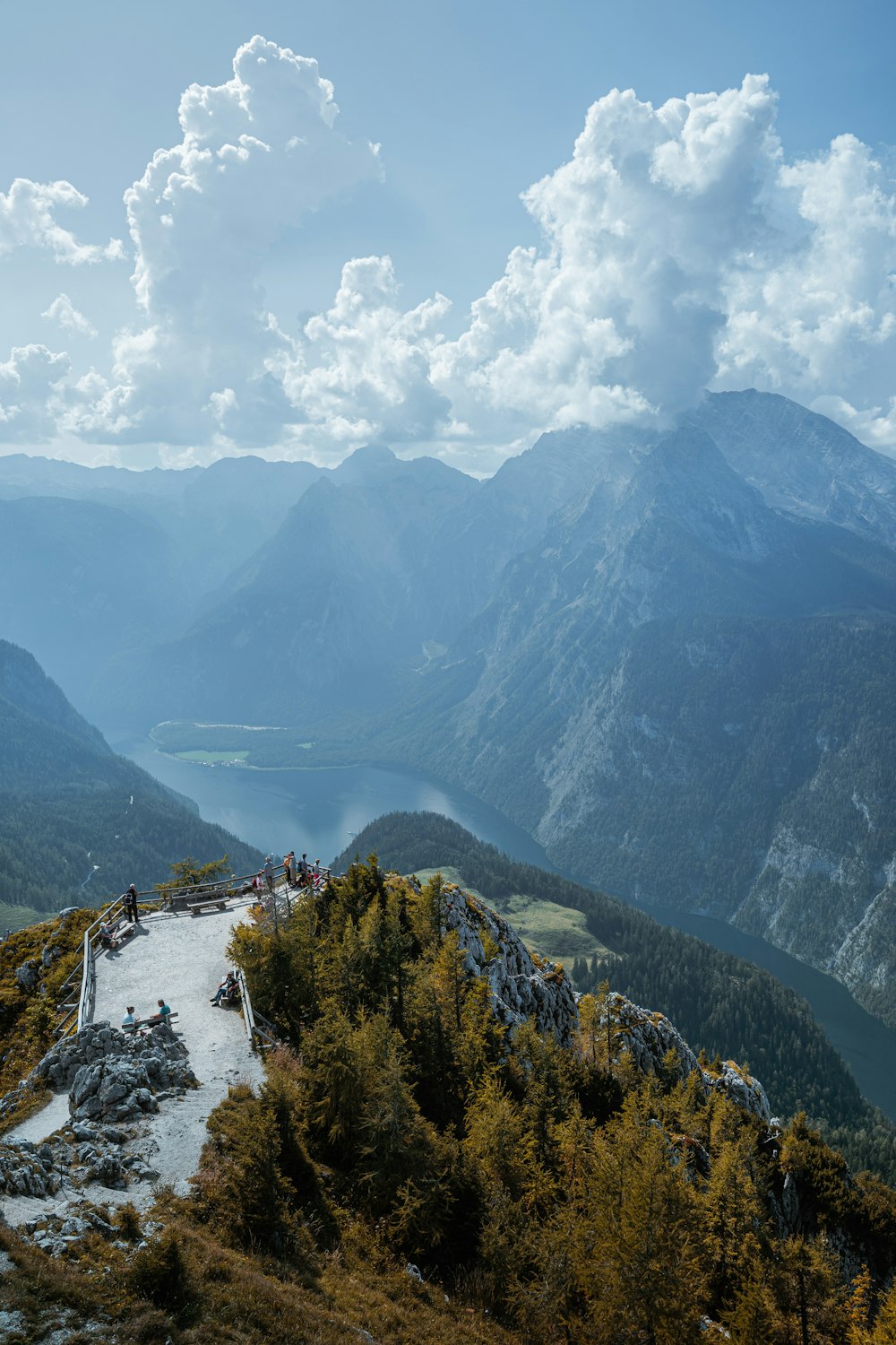 Grüne Bäume auf dem Berg tagsüber unter weißen Wolken