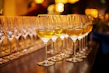 A set of crystal-clear wine glasses arranged on a wooden table with a warm glow.