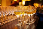 A set of crystal-clear wine glasses arranged on a wooden table with a warm glow.
