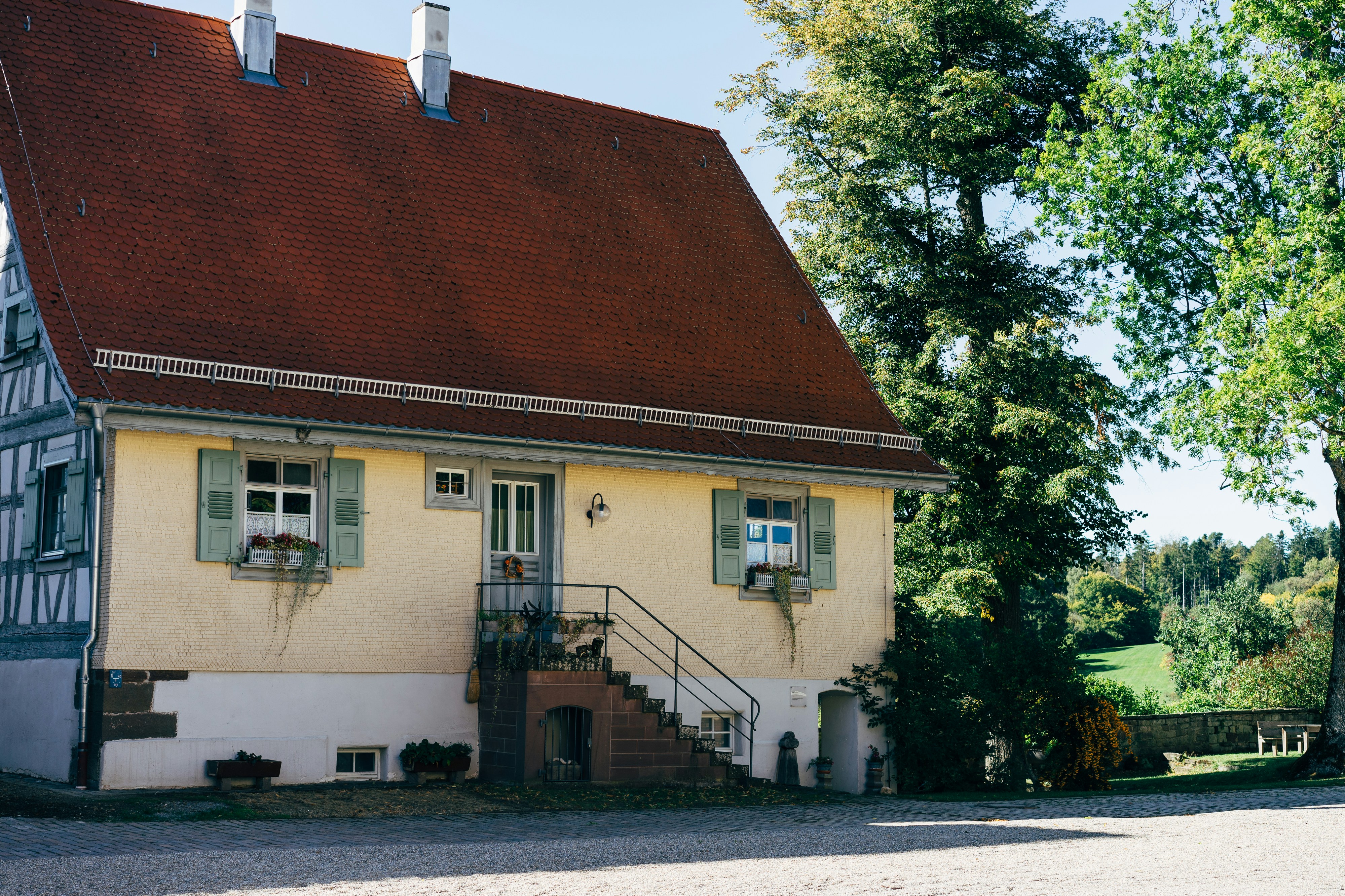 white and brown concrete house near green trees during daytime