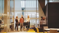 A foosball table set up in a university common area, with students gathered around playing.