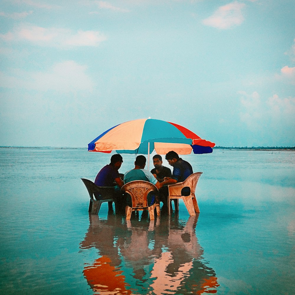 people sitting on beach chairs under blue sky during daytime