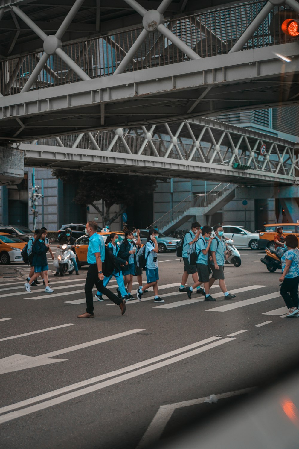 people in blue and orange shirts running on road during daytime