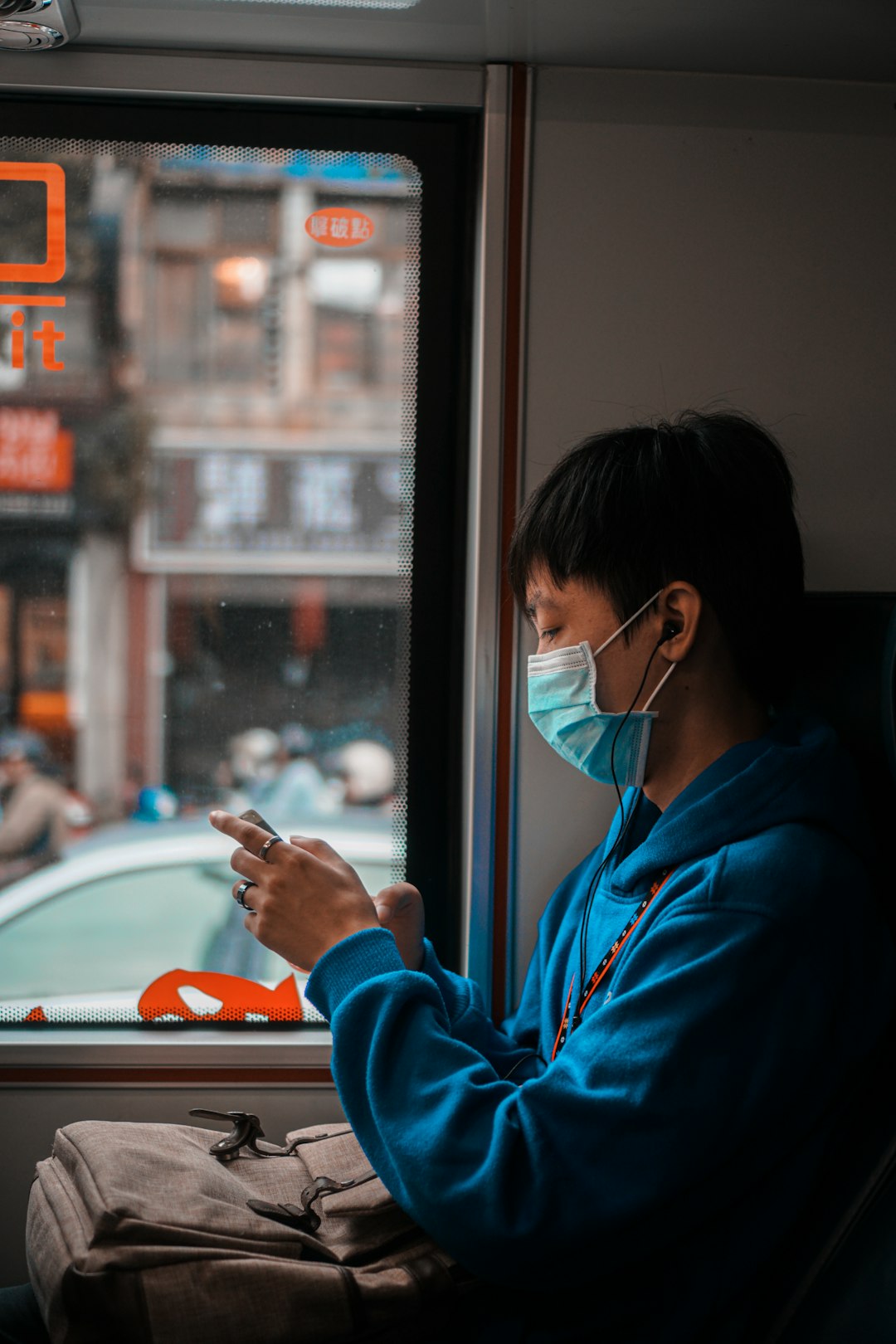 woman in blue hoodie using smartphone