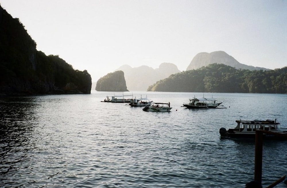 white boat on sea near mountain during daytime