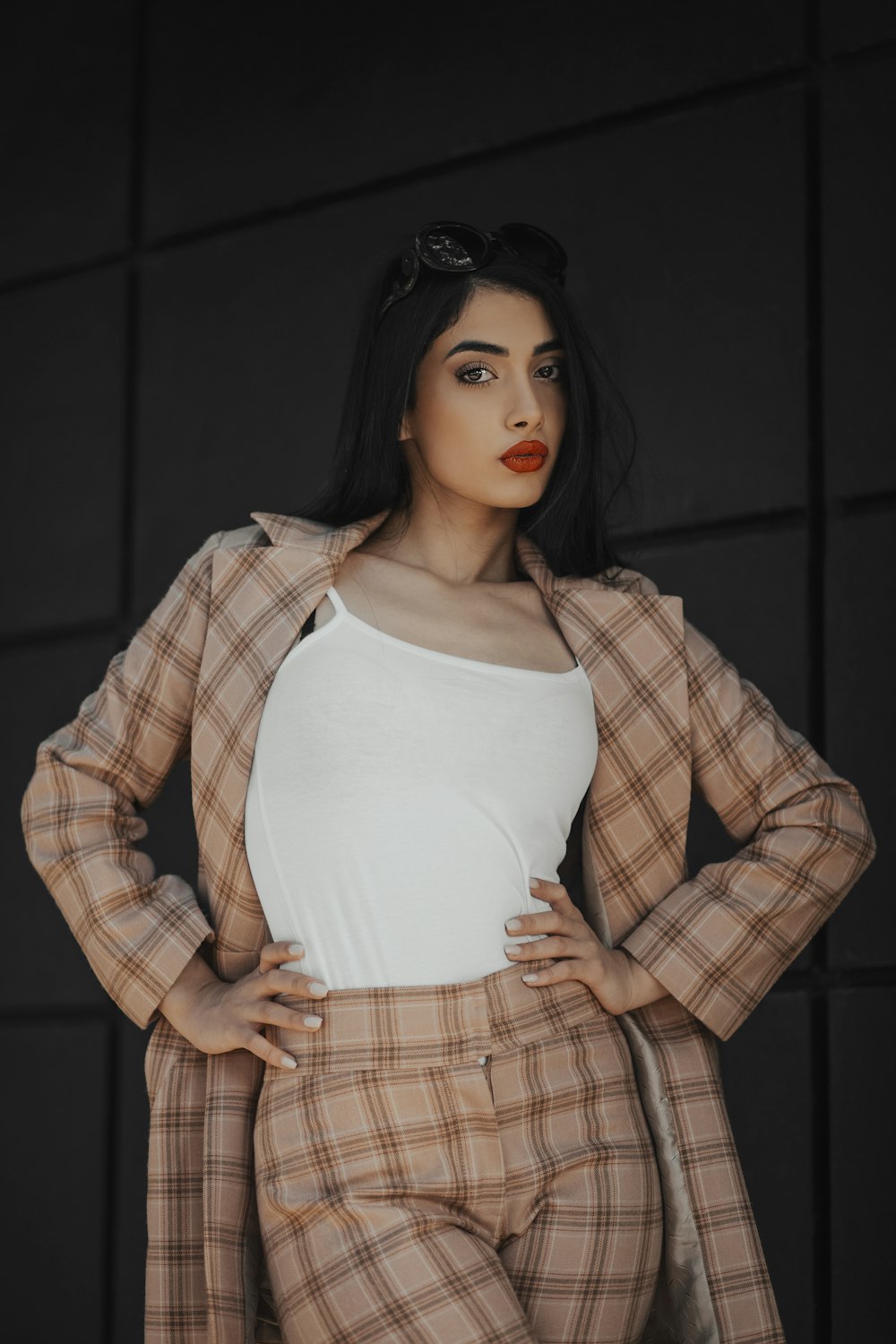 woman in white tank top and brown plaid blazer