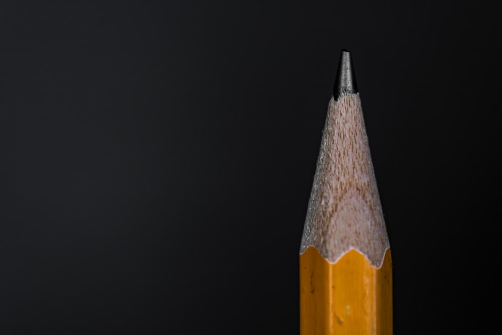 gelber und schwarzer Bleistift auf schwarzem Hintergrund