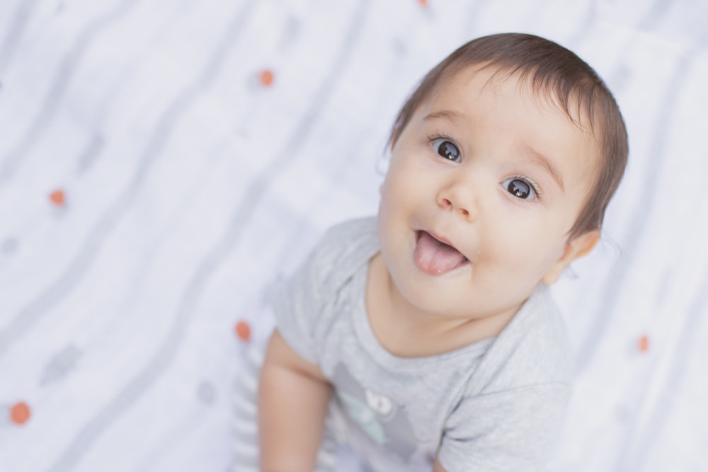 Bebé en camiseta blanca de cuello redondo sonriendo
