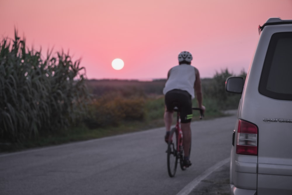 man in black shirt riding bicycle on road during daytime