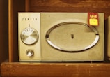 A vintage Zenith radio with a tuning dial and speaker grille, set within a wooden shelf. A 'Sale' tag with a handwritten price is attached to the radio.