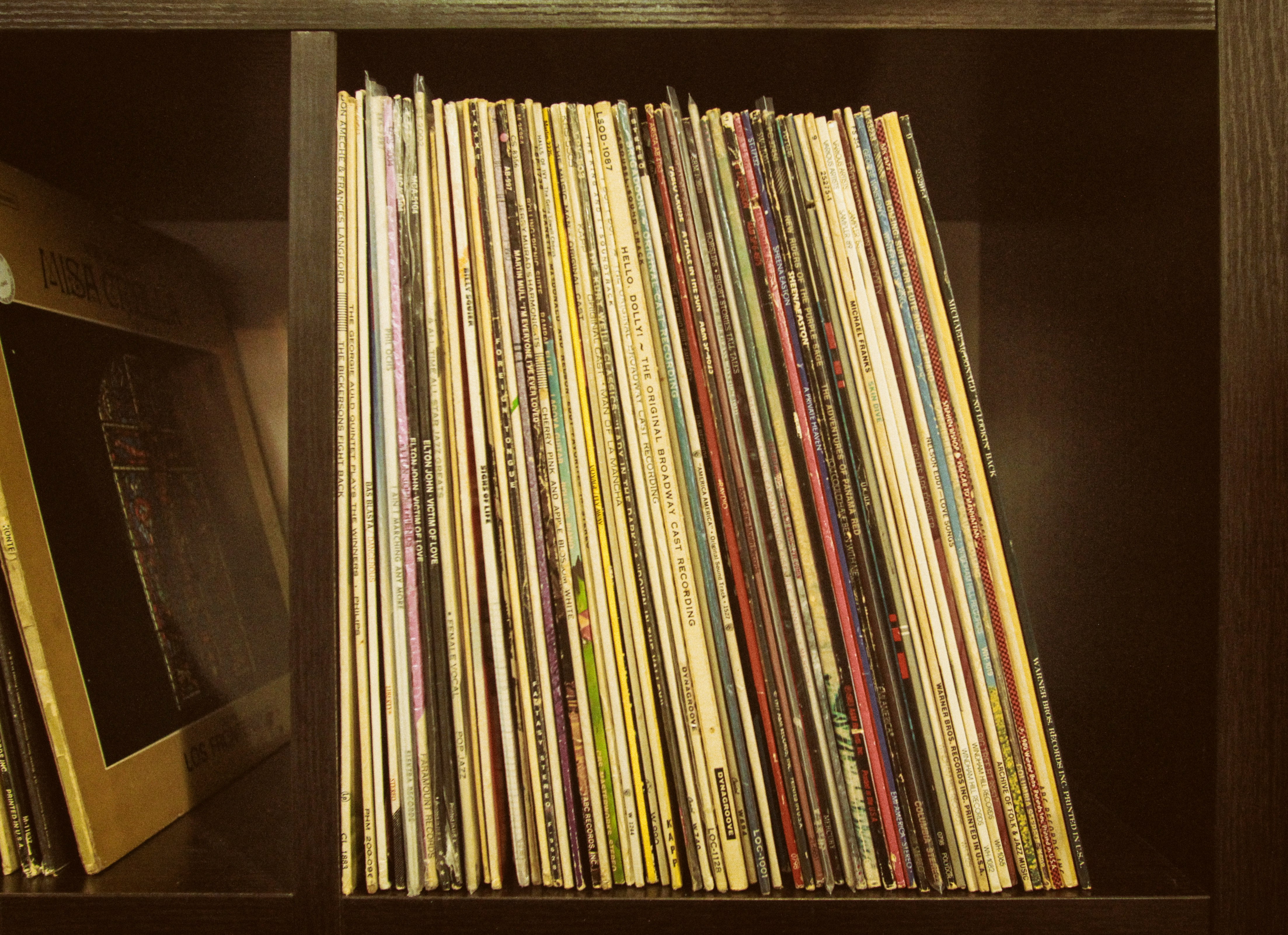 brown and white books on brown wooden shelf