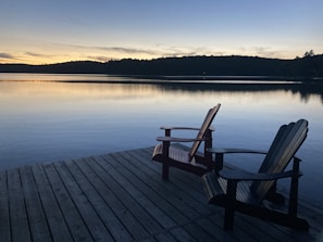 brown wooden bench on dock near lake during daytime