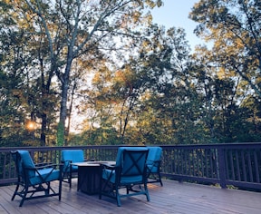 black metal chairs and table near green trees during daytime