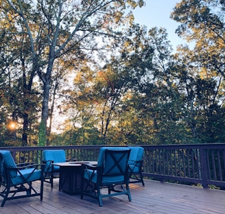 black metal chairs and table near green trees during daytime