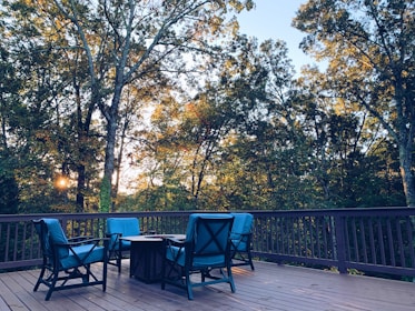 black metal chairs and table near green trees during daytime