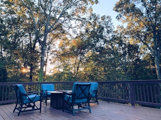 black metal chairs and table near green trees during daytime