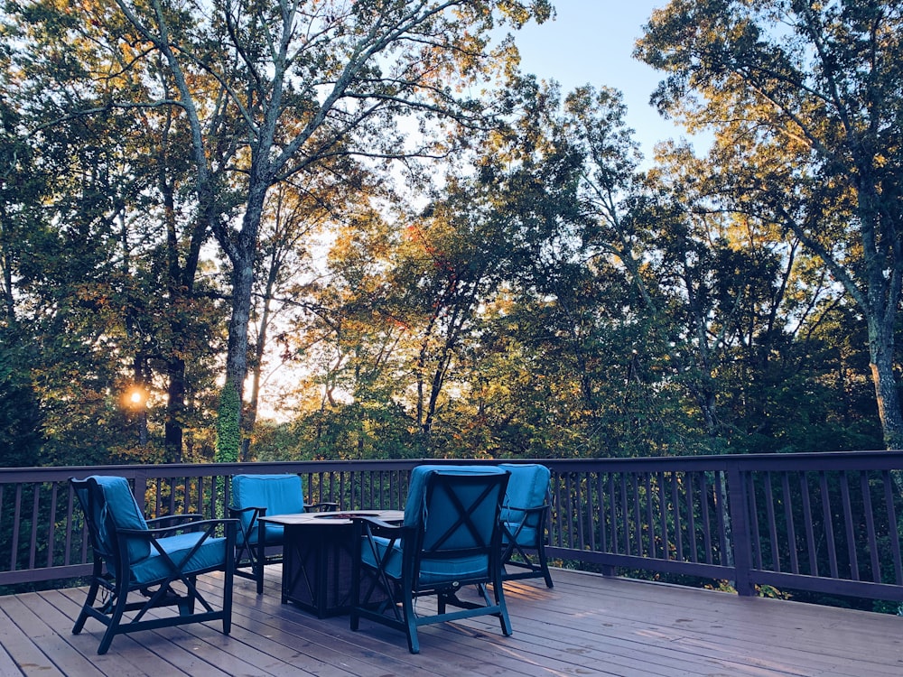 black metal chairs and table near green trees during daytime