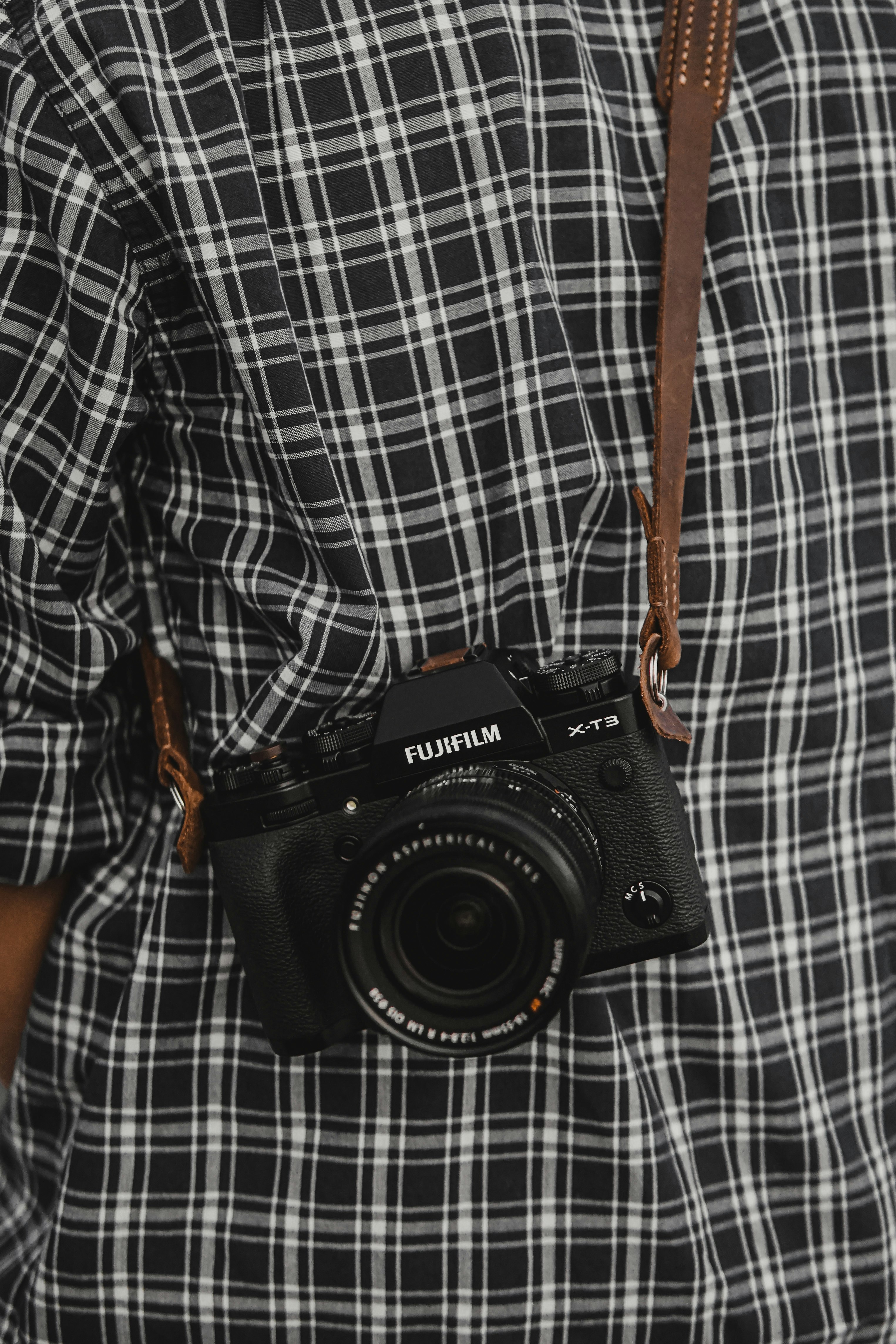 black nikon dslr camera on white and black checkered textile