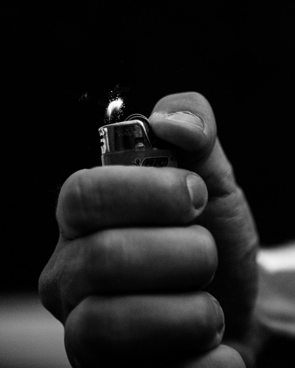 grayscale photo of person holding lighter