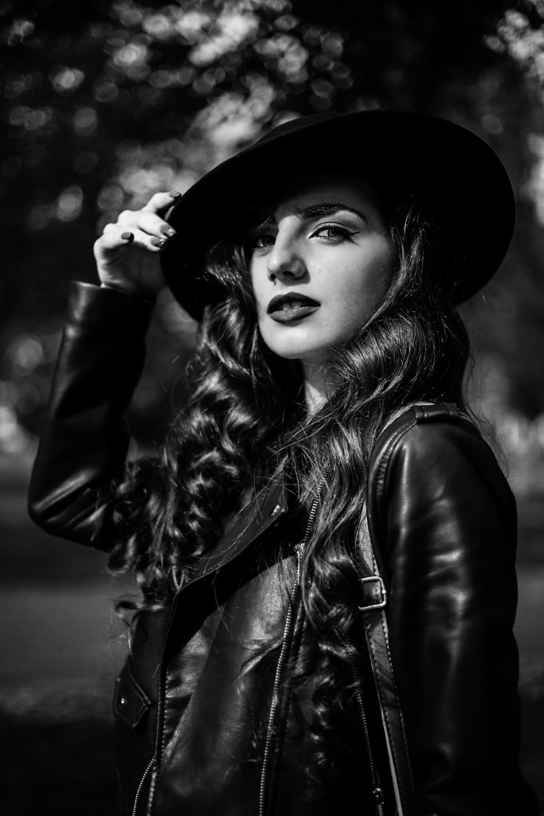 woman in black leather jacket and black hat