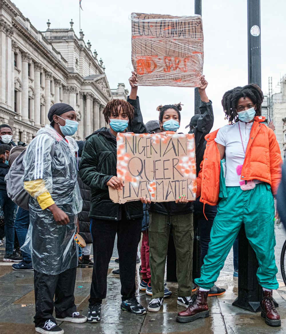 group of people holding orange and white banner