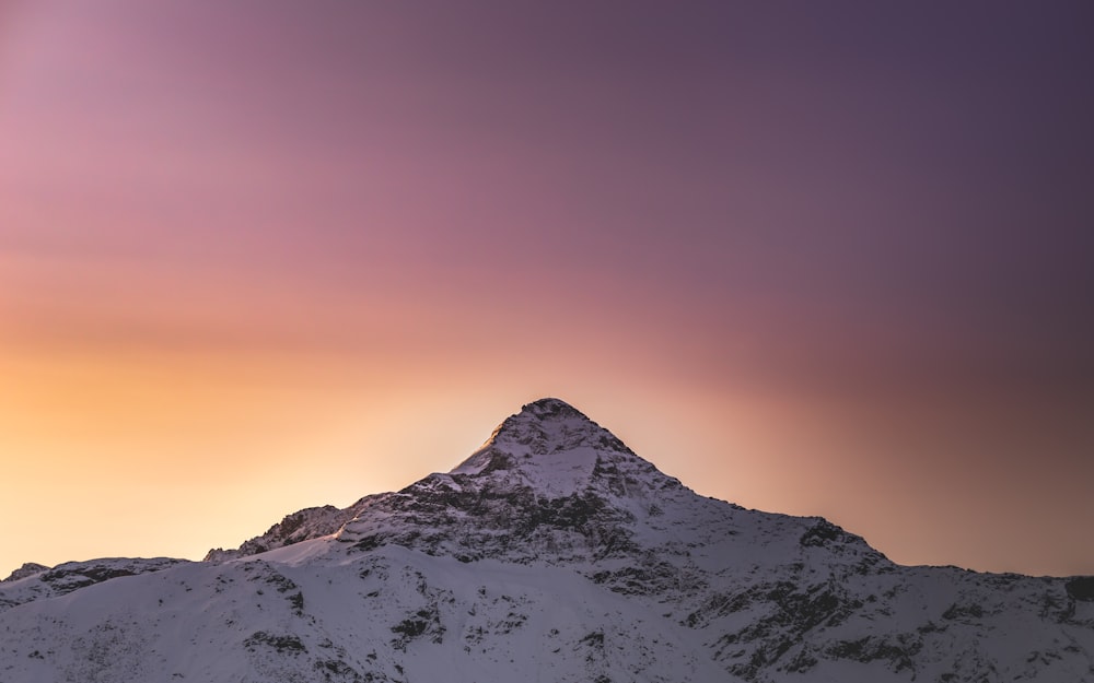 montanha coberta de neve durante o pôr do sol