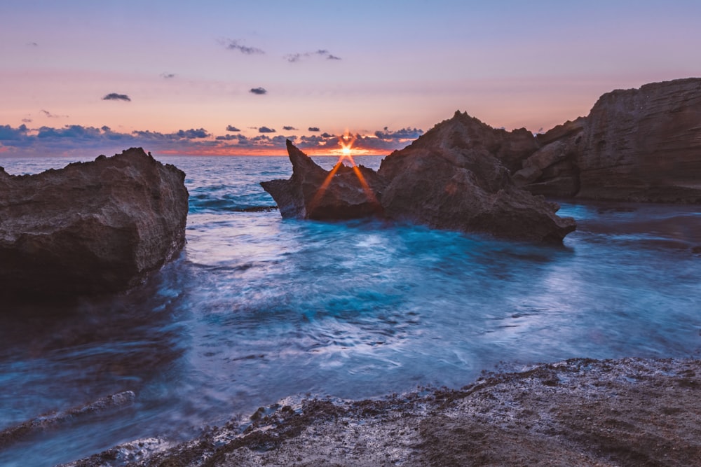 brown rock formation on sea during daytime