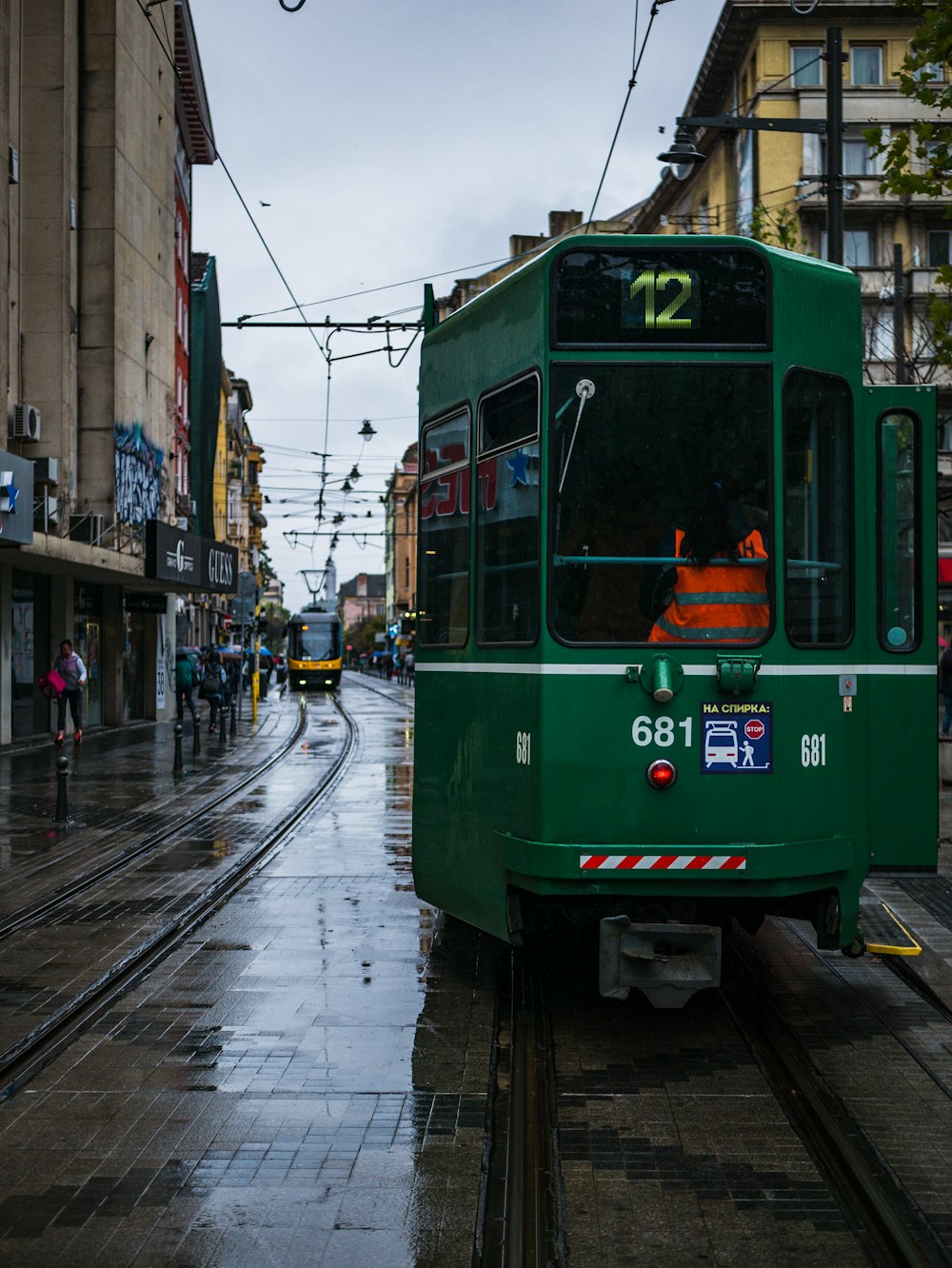 green tram on the street during daytime