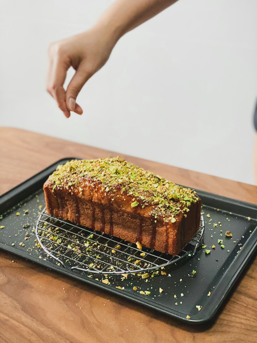 person holding brown bread on black tray