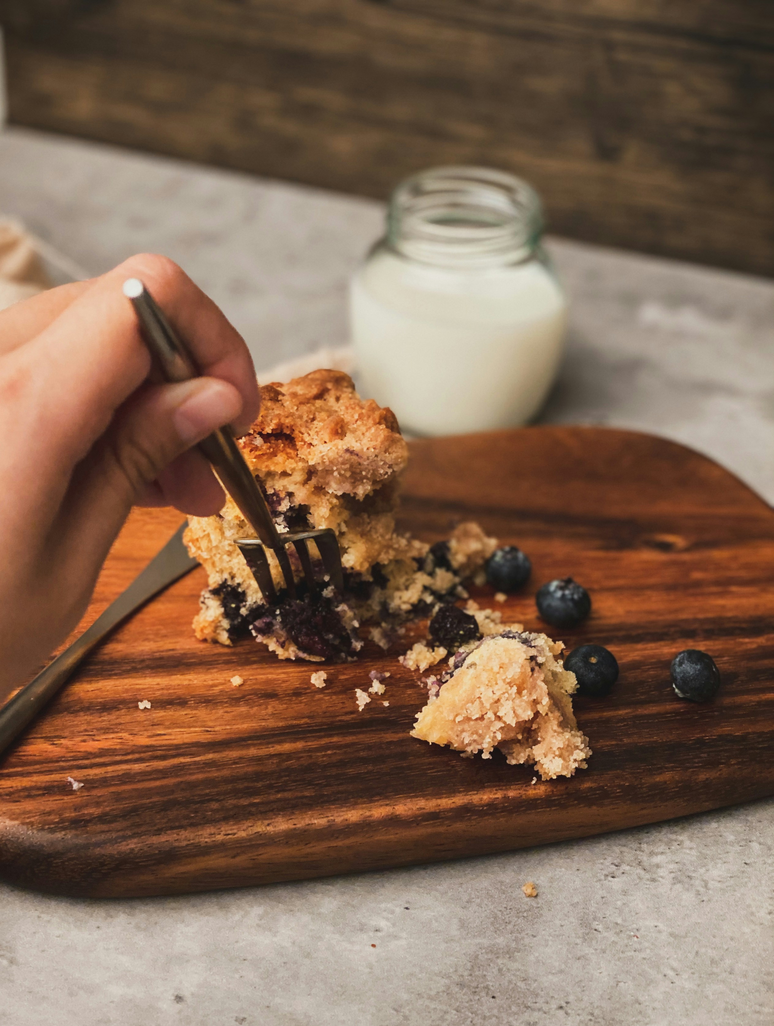 person holding brown wooden chopping board with white powder