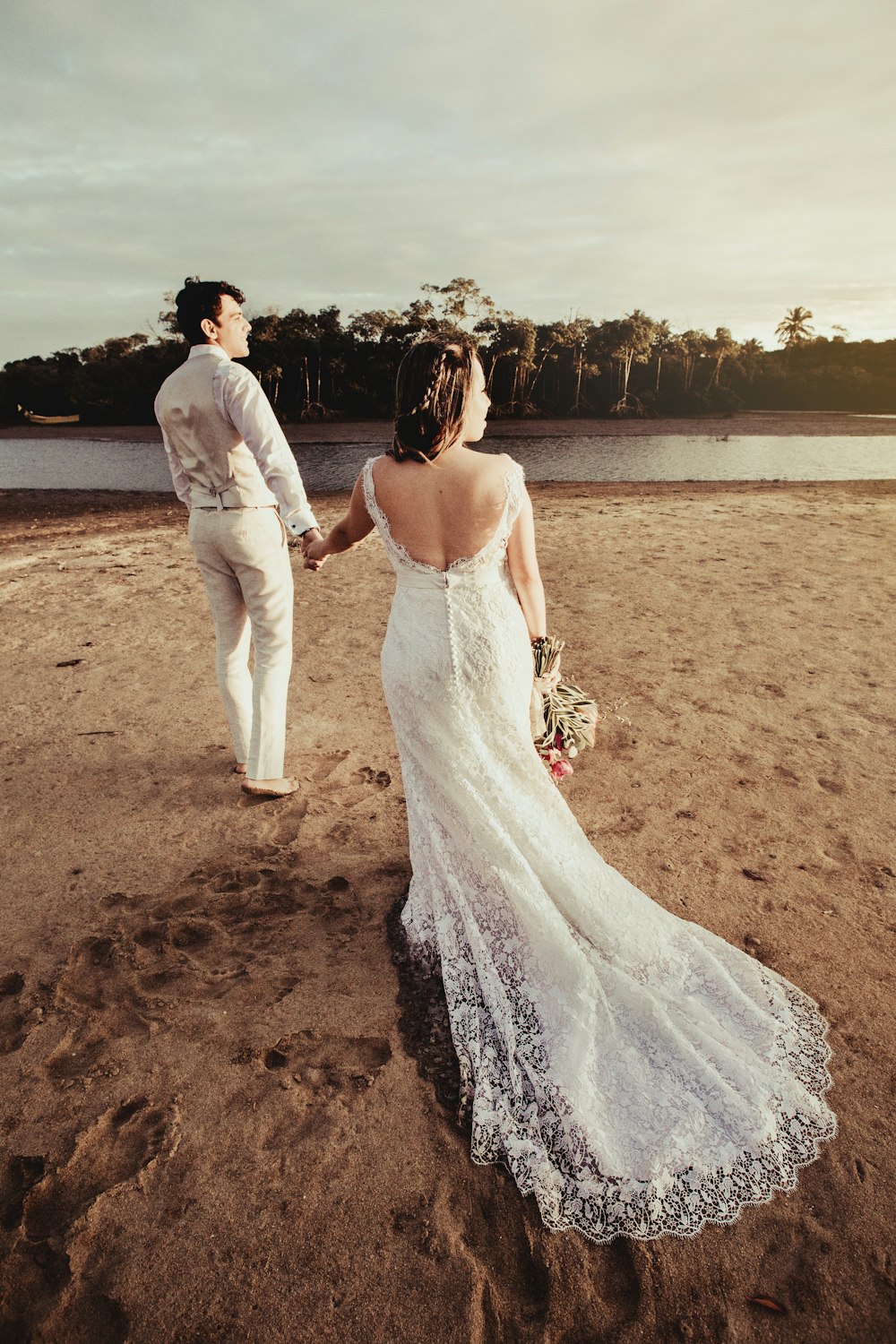 woman in white dress standing beside man in white suit