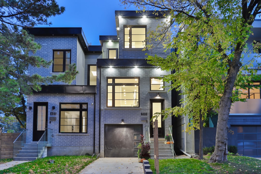 brown and white concrete house near green trees during daytime