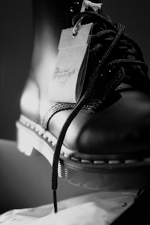 Close-up of black leather ankle boots set against a crisp white background emphasizing texture and style.