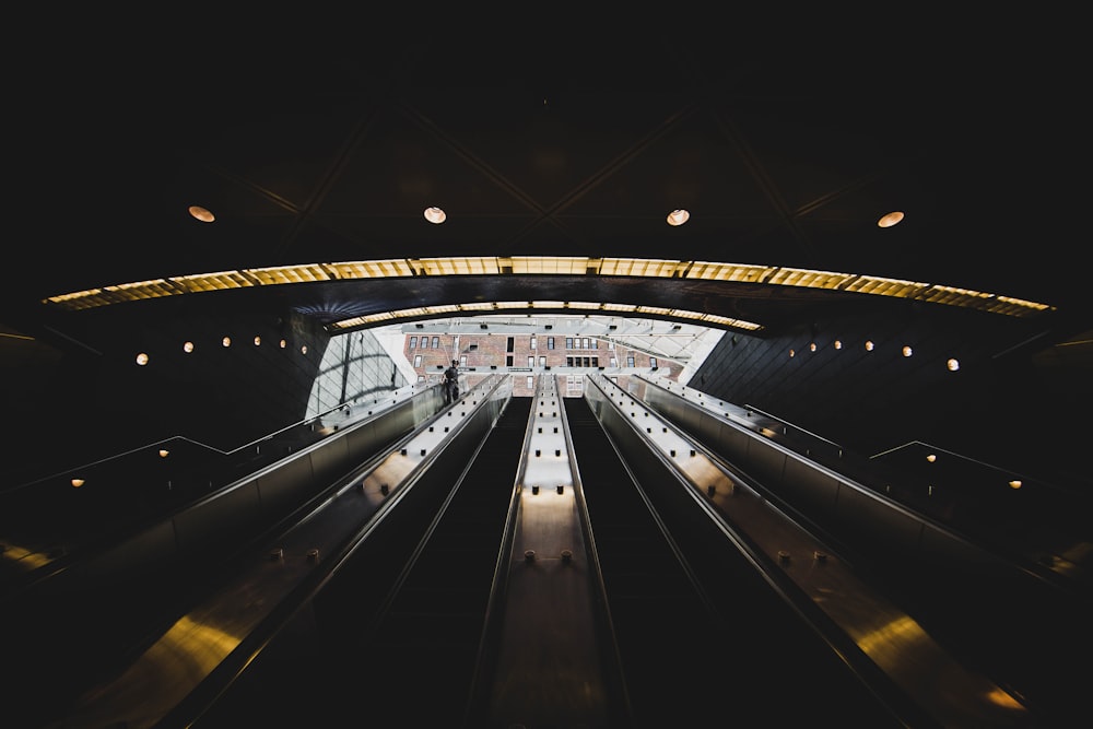 white and black escalator in a tunnel