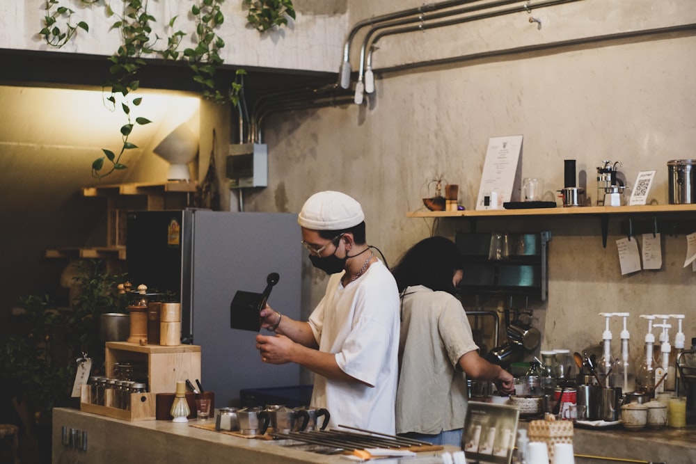 man in white chef uniform holding black smartphone