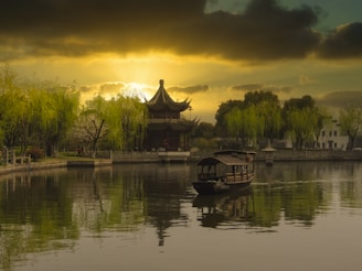 brown wooden house on lake during sunset