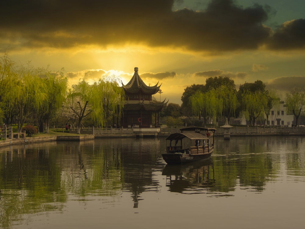 brown wooden house on lake during sunset