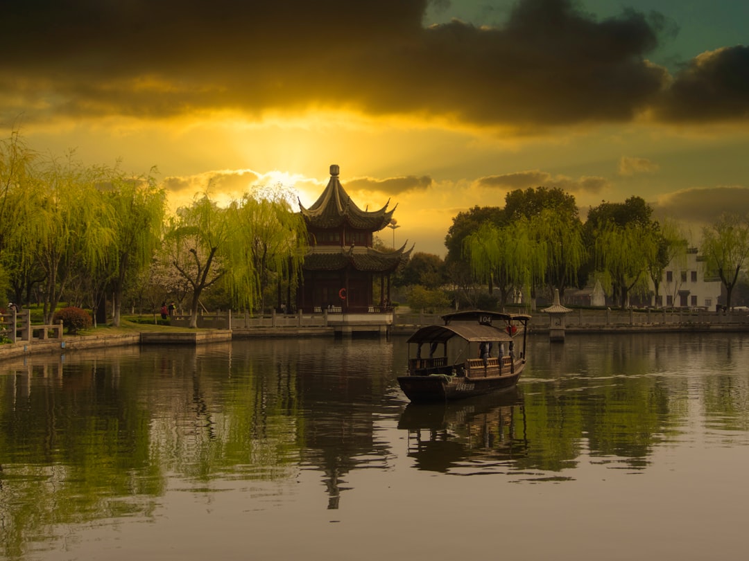 brown wooden house on lake during sunset