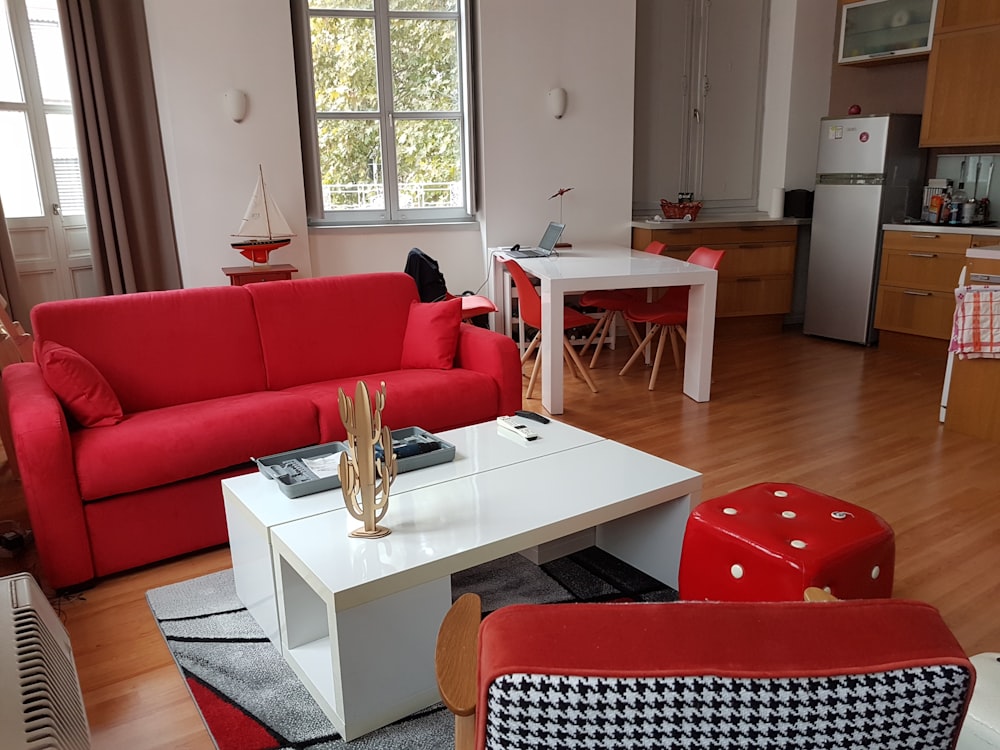 white wooden coffee table with red sofa chairs