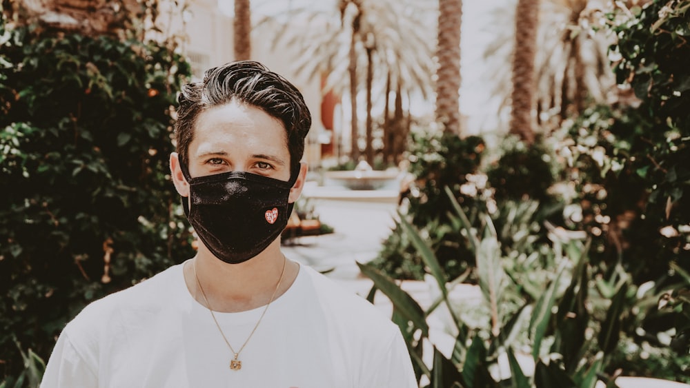 man in white crew neck shirt wearing black mask