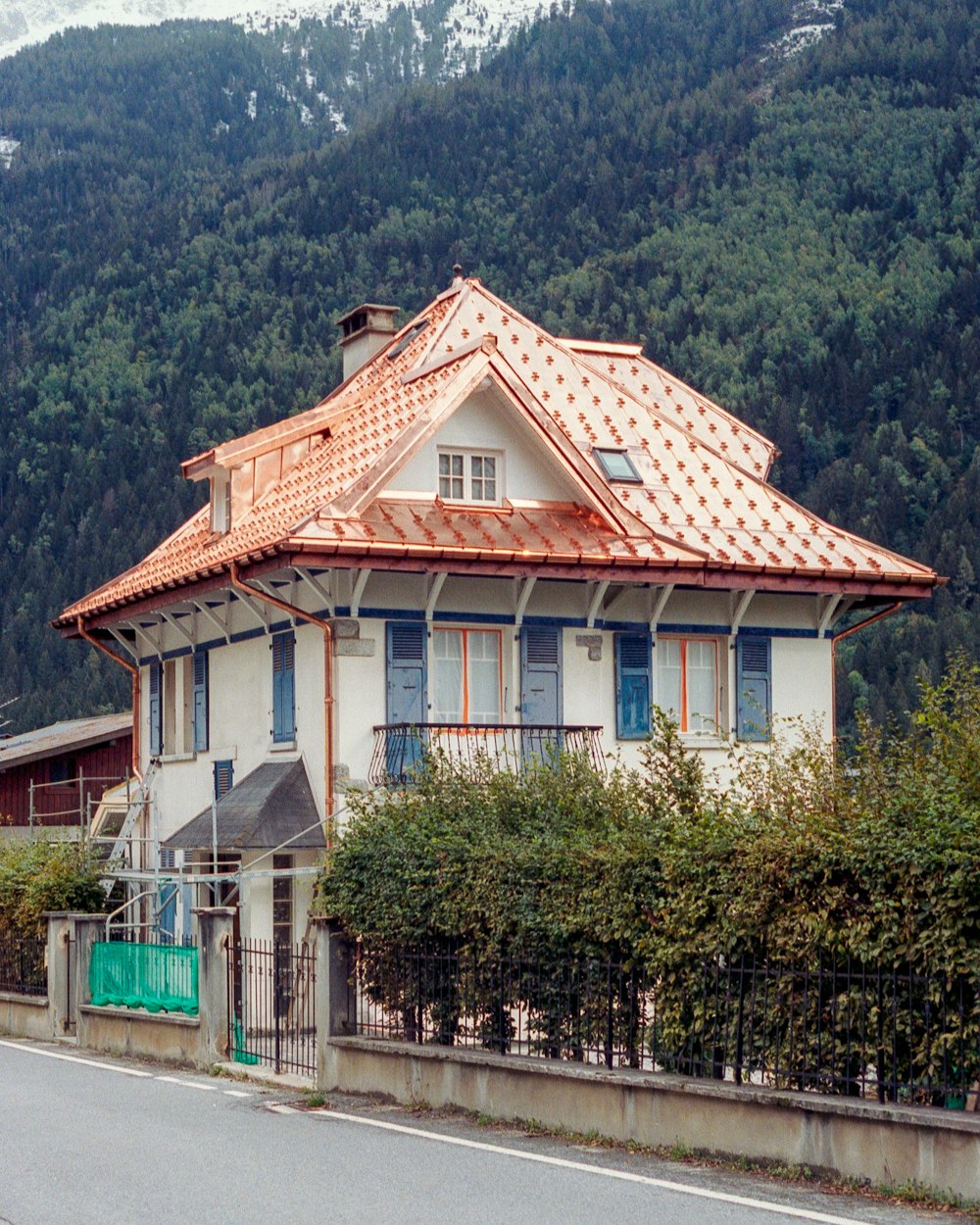 white and brown concrete house near green trees during daytime