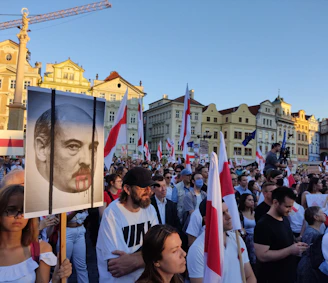 A vibrant crowd waving flags and banners supporting Gonzalo in a sunny Dominican Republic plaza.
