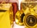 Several decorative gift boxes are wrapped in shiny red and gold paper and adorned with golden strings. A couple of small golden bells are placed in front of the boxes, adding a festive touch.