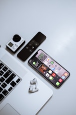 black iphone 4 beside white apple wireless keyboard and white wireless mouse