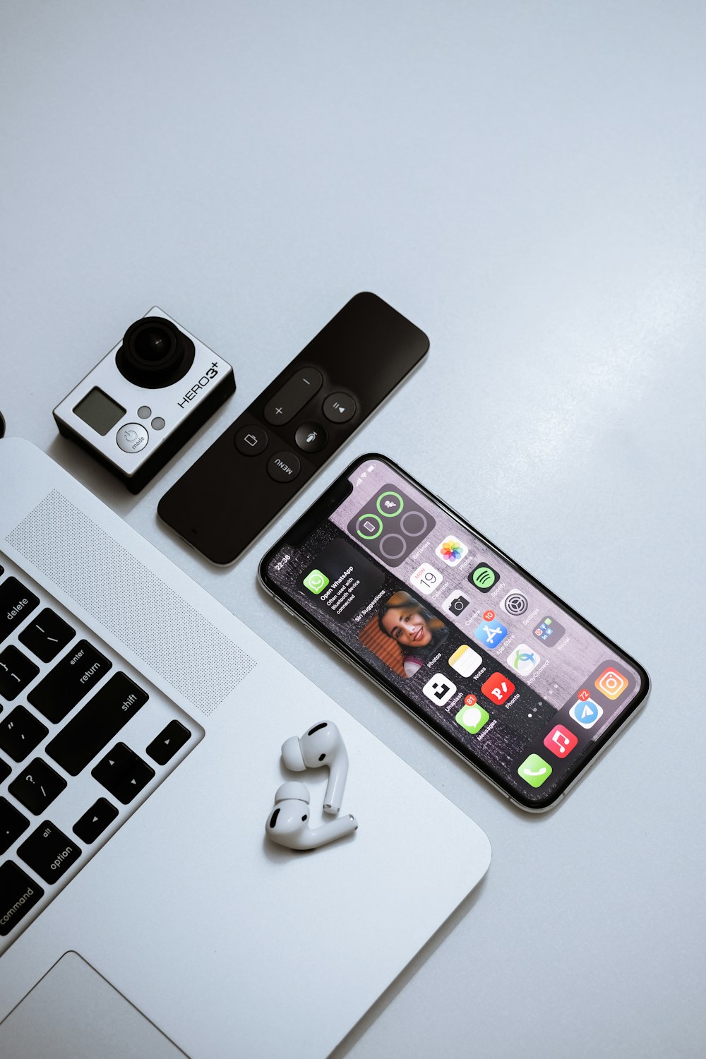 iPhone 4 negro junto al teclado inalámbrico blanco de Apple y el mouse inalámbrico blanco
